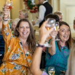 A group fo women raising their glasses in a toast