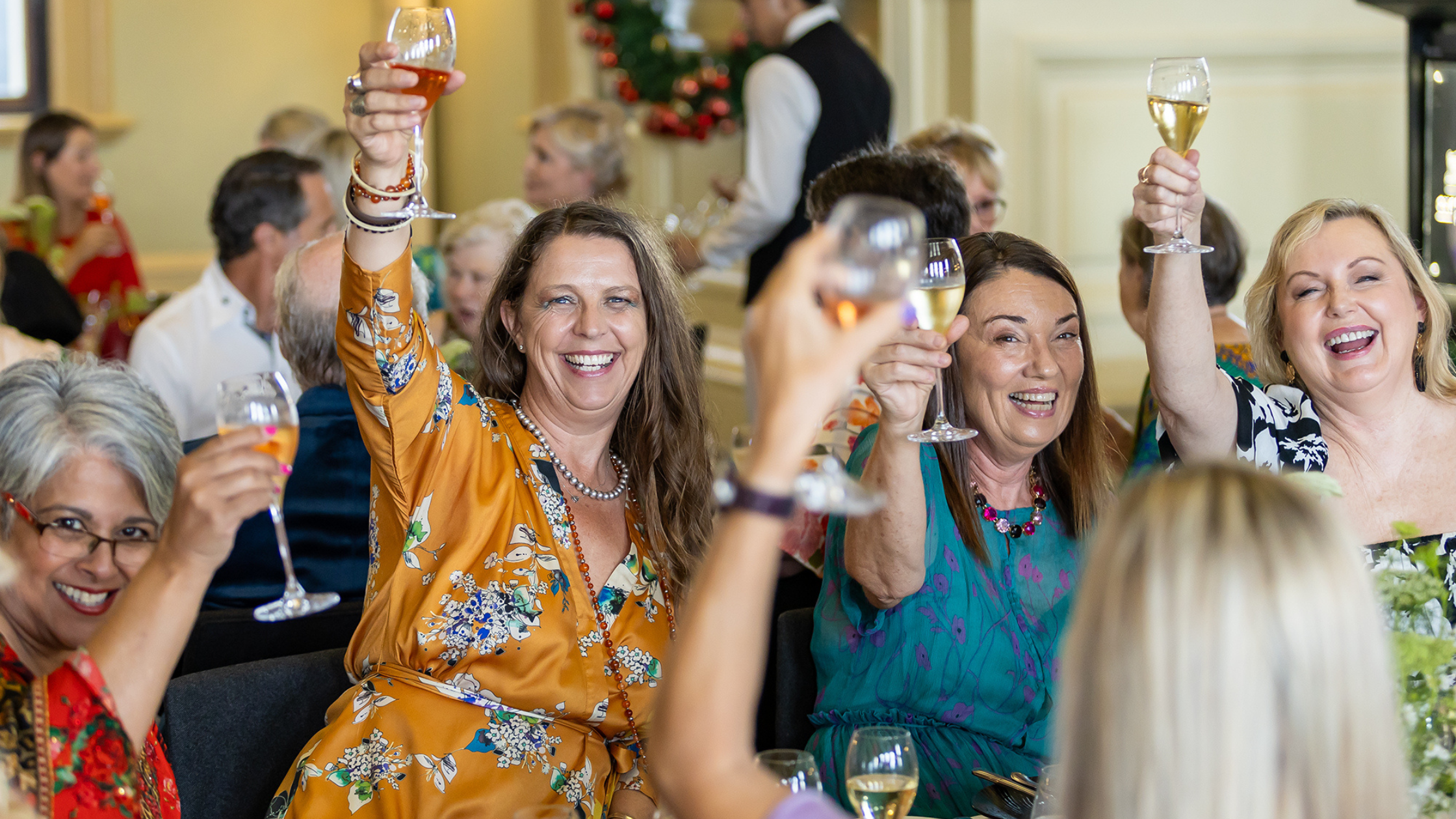 A group fo women raising their glasses in a toast